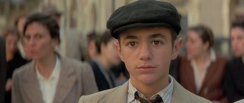 Movie still from “Malena” (2000), directed by Giuseppe Tornatore – A young man wearing a hat and a suit; Close Up shot, Low angle