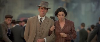 Movie still from “Malena” (2000), directed by Giuseppe Tornatore – A man and a woman standing next to each other; Medium shot, Low angle