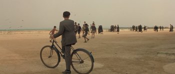 Movie still from “Malena” (2000), directed by Giuseppe Tornatore – A group of men playing soccer on the beach; Wide shot, High angle