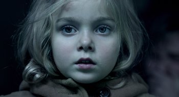 Movie still from “Mama” (2013), directed by Andy Muschietti – A young girl's face in a coat; Extreme Close Up shot, Overhead angle