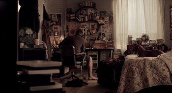Movie still from “Mama” (2013), directed by Andy Muschietti – A man sitting at a desk in front of a computer; Wide shot, High angle