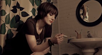 Movie still from “Mama” (2013), directed by Andy Muschietti – A woman smoking a cigarette while looking at her cell phone; Close Up shot, Low angle