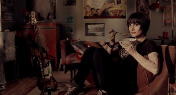 Movie still from “Mama” (2013), directed by Andy Muschietti – A woman sitting on the ground holding a book; Medium shot, High angle