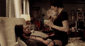 Movie still from “Mama” (2013), directed by Andy Muschietti – A man and a woman are in a room; Medium shot, High angle