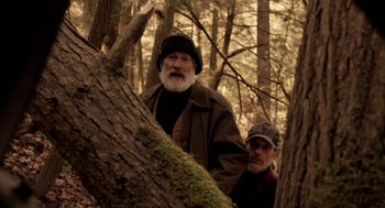 Movie still from “Mama” (2013), directed by Andy Muschietti – Two men standing next to each other in the woods; Medium shot, Low angle