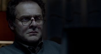 Movie still from “Mama” (2013), directed by Andy Muschietti – A person wearing glasses; Close Up shot, Over the shoulder angle