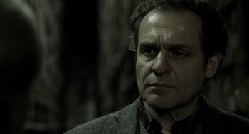 Movie still from “Mama” (2013), directed by Andy Muschietti – A person wearing a suit and tie; Close Up shot, Low angle