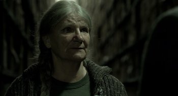 Movie still from “Mama” (2013), directed by Andy Muschietti – An older woman wearing a green shirt looking up; Close Up shot, Over the shoulder angle