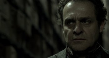 Movie still from “Mama” (2013), directed by Andy Muschietti – A person wearing a suit and tie; Close Up shot, Low angle