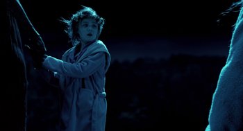 Movie still from “Mama” (2013), directed by Andy Muschietti – A young girl wearing a robe in the dark; Medium shot, Low angle