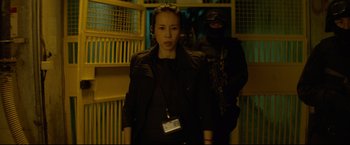 Movie still from “Man of Tai Chi” (2013), directed by Keanu Reeves – A woman in a black jacket standing next to a man in a black jacket; Medium shot, Low angle