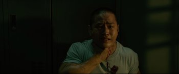 Movie still from “Man of Tai Chi” (2013), directed by Keanu Reeves – A man with a bleeding heart on his chest; Close Up shot, Low angle