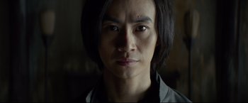 Movie still from “Man of Tai Chi” (2013), directed by Keanu Reeves – A person with long black hair; Close Up shot, Low angle