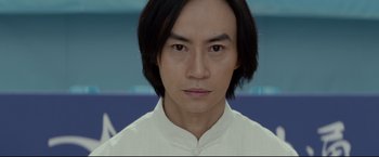 Movie still from “Man of Tai Chi” (2013), directed by Keanu Reeves – A person wearing a white shirt; Close Up shot, Low angle