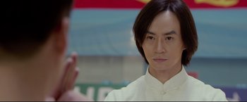 Movie still from “Man of Tai Chi” (2013), directed by Keanu Reeves – A man in a white shirt is taking a picture of himself; Close Up shot, Over the shoulder angle