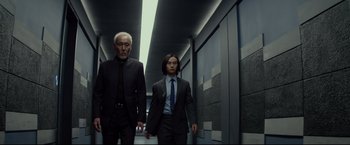 Movie still from “Man of Tai Chi” (2013), directed by Keanu Reeves – A man and a woman in suits walking down a hall way; Medium shot, Low angle
