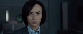 Movie still from “Man of Tai Chi” (2013), directed by Keanu Reeves – A person wearing a suit and tie; Close Up shot, Low angle