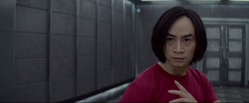 Movie still from “Man of Tai Chi” (2013), directed by Keanu Reeves – A woman in a red shirt is posing for a picture; Close Up shot, Low angle