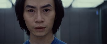 Movie still from “Man of Tai Chi” (2013), directed by Keanu Reeves – A person with long black hair; Close Up shot, Over the shoulder angle