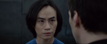 Movie still from “Man of Tai Chi” (2013), directed by Keanu Reeves – A man with long black hair is looking at another man with short black hair; Close Up shot, Over the shoulder angle