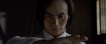 Movie still from “Man of Tai Chi” (2013), directed by Keanu Reeves – A person wearing a white shirt; Close Up shot, Low angle