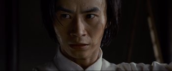 Movie still from “Man of Tai Chi” (2013), directed by Keanu Reeves – A person with long hair; Close Up shot, Low angle