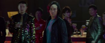 Movie still from “Man of Tai Chi” (2013), directed by Keanu Reeves – A man standing in front of a group of people; Medium shot, Over the shoulder angle