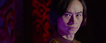 Movie still from “Man of Tai Chi” (2013), directed by Keanu Reeves – A person wearing a purple shirt; Close Up shot, Low angle