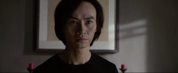 Movie still from “Man of Tai Chi” (2013), directed by Keanu Reeves – A person wearing a black shirt; Close Up shot, Low angle