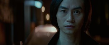 Movie still from “Man of Tai Chi” (2013), directed by Keanu Reeves – A person with long black hair; Close Up shot, Low angle
