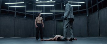 Movie still from “Man of Tai Chi” (2013), directed by Keanu Reeves – A man is lying on the ground next to another man; Wide shot, Low angle