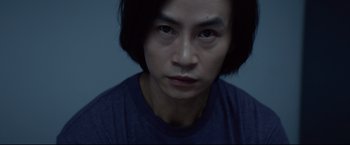 Movie still from “Man of Tai Chi” (2013), directed by Keanu Reeves – A person wearing a blue t - shirt; Close Up shot, Low angle