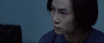 Movie still from “Man of Tai Chi” (2013), directed by Keanu Reeves – A person with long black hair; Close Up shot, Over the shoulder angle