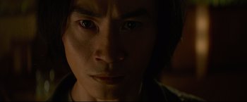 Movie still from “Man of Tai Chi” (2013), directed by Keanu Reeves – A man's face in the dark; Close Up shot, Low angle