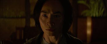 Movie still from “Man of Tai Chi” (2013), directed by Keanu Reeves – A person with long black hair; Close Up shot, Low angle