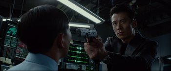 Movie still from “Man of Tai Chi” (2013), directed by Keanu Reeves – A man holding a gun up to another man's face; Close Up shot, Over the shoulder angle