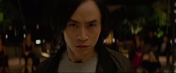 Movie still from “Man of Tai Chi” (2013), directed by Keanu Reeves – A person with long black hair; Close Up shot, Low angle