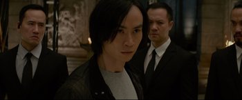 Movie still from “Man of Tai Chi” (2013), directed by Keanu Reeves – A man in a black jacket standing next to another man in a black jacket; Close Up shot, Over the shoulder angle