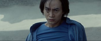 Movie still from “Man of Tai Chi” (2013), directed by Keanu Reeves – A person wearing a blue shirt; Close Up shot, Low angle
