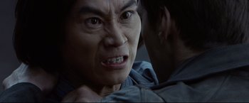 Movie still from “Man of Tai Chi” (2013), directed by Keanu Reeves – An asian man with a very angry look on his face; Close Up shot, Over the shoulder angle