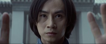 Movie still from “Man of Tai Chi” (2013), directed by Keanu Reeves – A person's face with long black hair; Close Up shot, Low angle