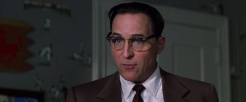 Movie still from “Man on the Moon” (1999), directed by Milos Forman – A person wearing a suit and glasses; Close Up shot, Low angle