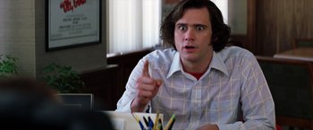 Movie still from “Man on the Moon” (1999), directed by Milos Forman – A man is sitting at a table with a bunch of colored pencils; Close Up shot, Over the shoulder angle