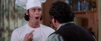 Movie still from “Man on the Moon” (1999), directed by Milos Forman – A man wearing a chef's hat and apron talking to another man; Close Up shot, Low angle