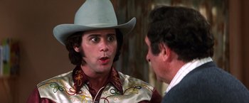 Movie still from “Man on the Moon” (1999), directed by Milos Forman – A man wearing a cowboy hat talking to another man; Close Up shot, Over the shoulder angle