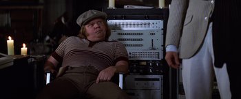 Movie still from “Man on the Moon” (1999), directed by Milos Forman – A man sitting in front of an electronic device; Medium shot, Over the shoulder angle