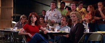 Movie still from “Man on the Moon” (1999), directed by Milos Forman – A group of people sitting at a table with plates of food on it; Medium shot, Over the shoulder angle