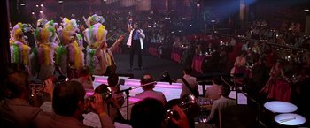 Movie still from “Man on the Moon” (1999), directed by Milos Forman – A crowd of people watching a man sing on a stage; Extreme Wide shot, Low angle