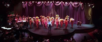 Movie still from “Man on the Moon” (1999), directed by Milos Forman – A group of women are performing on a stage; Extreme Wide shot, High angle