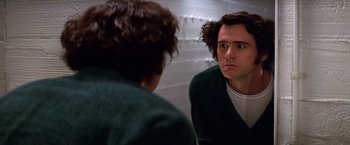 Movie still from “Man on the Moon” (1999), directed by Milos Forman – A man looking at himself in the mirror in front of a wall; Close Up shot, Low angle